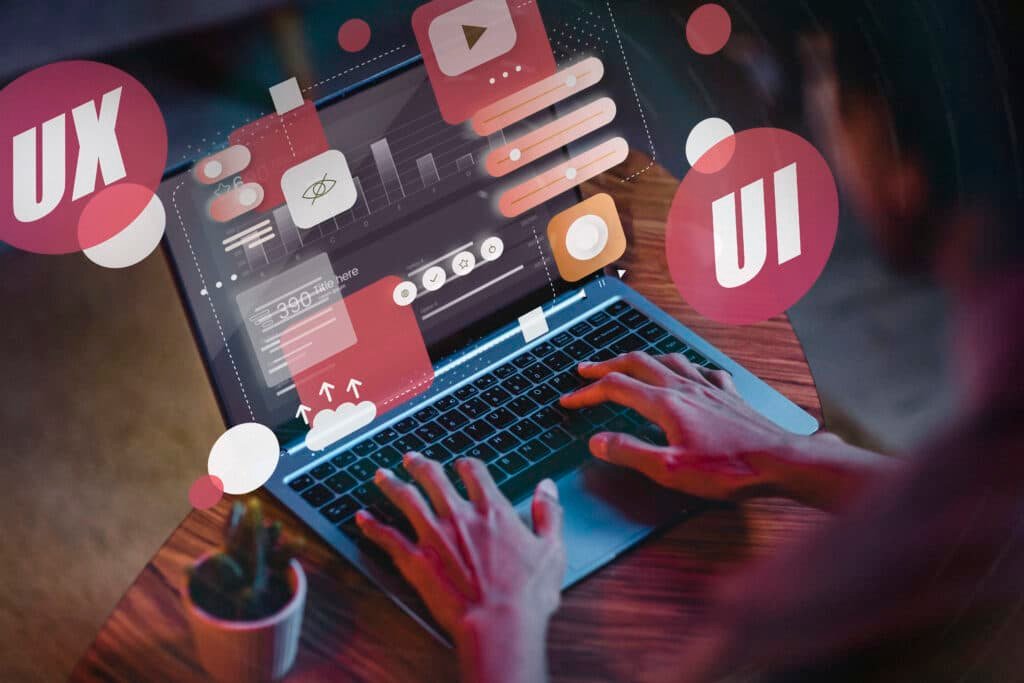 Pessoa trabalhando no design UI/UX de site com elementos visuais interativos na tela do notebook
